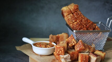 crispy pork belly in a basket with spicy sauce 