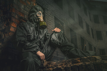 Beautiful military girl. Portrait of a woman with a gas mask in a destroyed building. Post-apocalypse concept