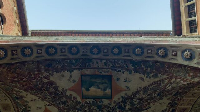 Beautiful medieval ceiling of Palazzo Chigi and blue sky in Siena, Tuscany, Italy