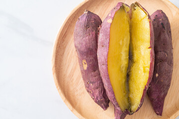 Grilled or baked Japanese sweet potatoes on wood plate