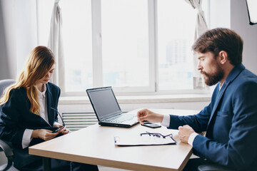 managers sitting at a desk with a laptop communication finance technologies