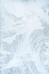 Fototapeta na wymiar Hoarfrost background. Ice pattern. Low temperature. Christmas card. Abstract winter snow ice crystals ornament texture on white blue frost frozen rime window pane glass surface.