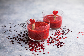 Fresh strawberry margarita or daiquiri cocktail with hearts over gray background, valentine day concepts