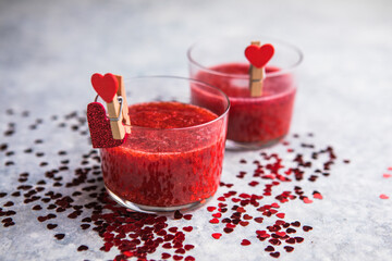 Fresh strawberry margarita or daiquiri cocktail with hearts over gray background, valentine day concepts