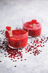 Fresh strawberry margarita or daiquiri cocktail with hearts over gray background, valentine day concepts