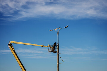 worker repair street lamp at height