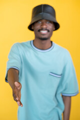 Nice meet you. Greeting hipster man. Friendly handshake. Happy guy in stylish leather hat proposing hand isolated yellow.
