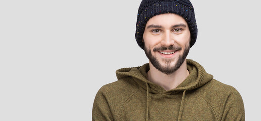 Closeup winter portrait of handsome smiling young man. Laughing joyful cheerful men isolated studio shot. Panoramic banner.