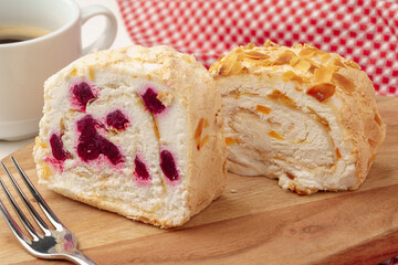 Biscuit roulade with cherry on wooden board
