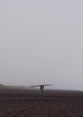 person carrying the surfboard