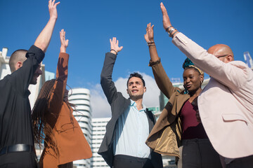 Business people putting their hands in air. Smart-dressed men and women of different nationalities during teambuilding process on terrace roof. Unity, teamwork, succsess concept