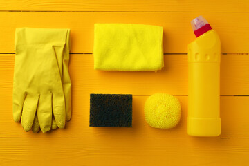 Cleaning tools composition flat lay on yellow wooden background