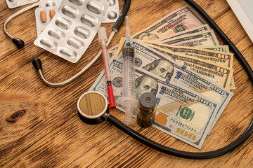 pills with dollar bills stethoscope syringe arranged on a new table