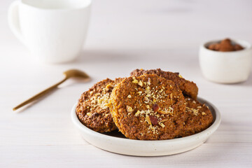 Homemade cookies with oatmeal, quinoa, carrots and nuts in a plate on a wooden table. Sugar, gluten and lactose free, vegan.
