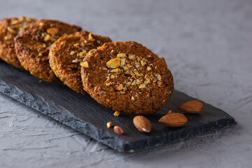 Homemade cookies with oatmeal, quinoa, carrots and nuts on a gray background. Sugar, gluten and lactose free, vegan.