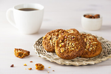 Homemade cookies with oatmeal, quinoa, carrots and nuts on a wicker stand. Sugar, gluten and lactose free, vegan.