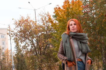 Pretty redhead woman in autumn fashion outfit Walking in city in fall