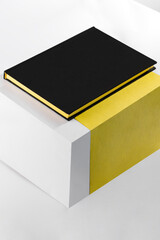 Black book cover on the white yellow cube background.