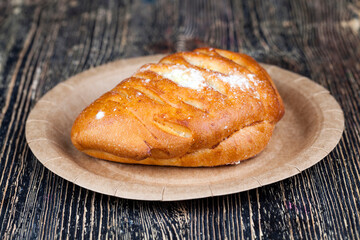 wheat flour bun, on a cardboard plate