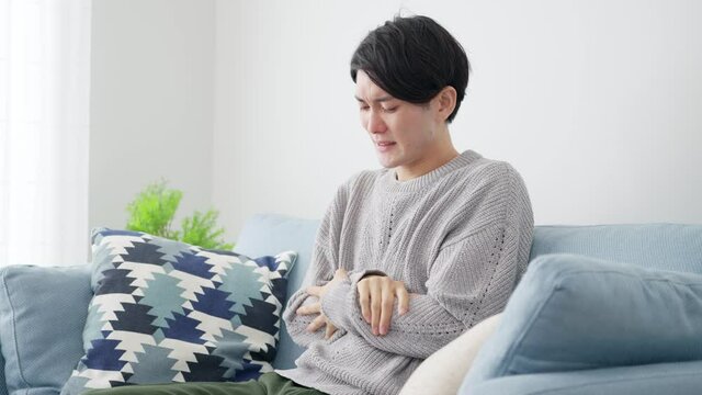 リビングで寒がる若い男性