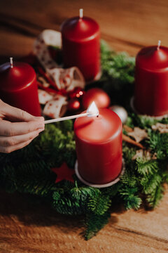 Lighting the first candle of Advent Wreath on the first Advent Sunday counting four weeks till Christmas. Old swiss tradition in December to celebrate Advent time.