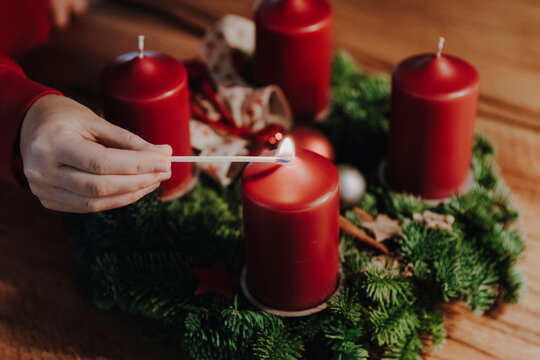 Lighting the first candle of Advent Wreath on the first Advent Sunday counting four weeks till Christmas. Old swiss tradition in December to celebrate Advent time.
