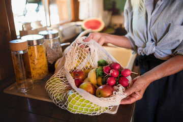 Close up of unrecognizable senior woman unpacking shopping indoors at home, sustainable lifestyle.