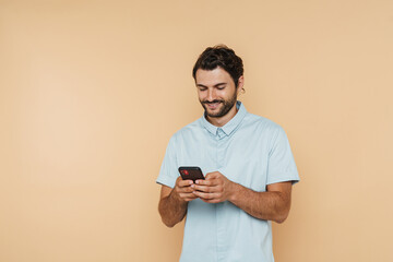 White bristle man wearing shirt smiling and using mobile phone
