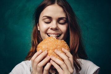 woman eating hamburger fast food snack close-up