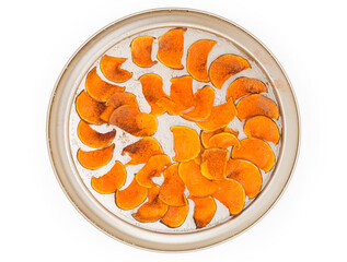 Top view of homemade pumpkin chips on round baking sheet