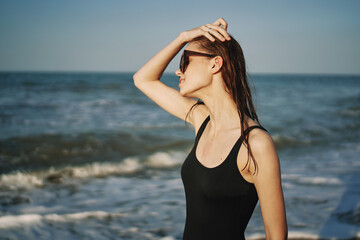 cheerful woman in black swimsuit sunglasses ocean travel