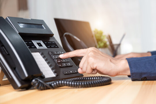 Call center staff man hand point to press the button number on the phone office desk , Communication support, call center and customer service help desk. for (call center) concept