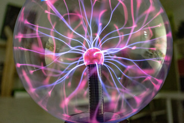 Closeup shot of a plasma ball with blue and pink blots. tesla ball