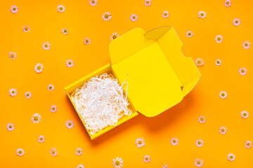 Flat cardboard box on yellow background empty inside, top view