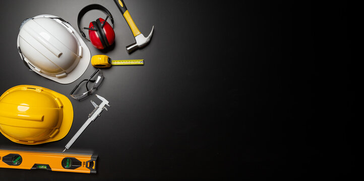 Work safety. Construction site protective equipment on wooden background, flat lay, copy space, top view