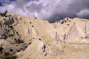 Fototapeta na wymiar White chalk mountain, quarry against the dark stormy sky