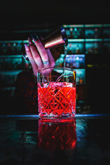 woman hand bartender making negroni cocktail in bar counter