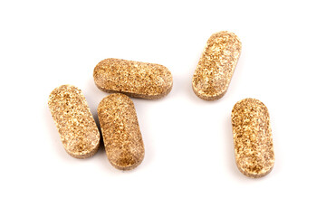 Nutrition supplements, brown vitamin pills on white background.