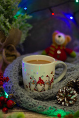Obraz na płótnie Canvas Embrace the holiday warmth with a delightful mug brimming with comfort, set against vibrant baubles, frosted pinecones, and a cheerful plush toy in the backdrop.