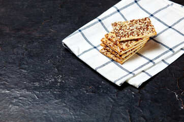 Crisp bread with seeds. Crunchy crispbread on a wooden background. Healthy snack: cereal crunchy multigrain cereal flax seed, sunflower seeds protein bread bar
