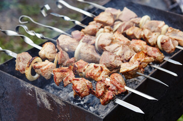 Marinated shashlik preparing on a barbecue grill over charcoal. Traditional Russian shashlik on a barbecue skewer