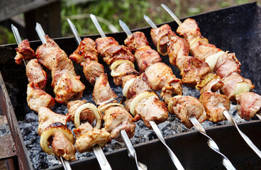 Marinated shashlik preparing on a barbecue grill over charcoal. Traditional Russian shashlik on a barbecue skewer