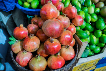 Pomegranate fruits and lemons in baskets at the street bazaar.