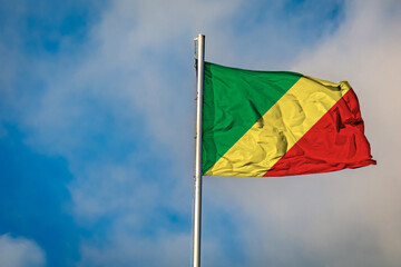 A Flag of the Republic of the Congo flying on a Flagpole against the Sky