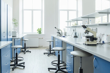 Microscopes at desk in bright empty laboratory