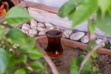 A Turkish cup with black tea is on the ground.