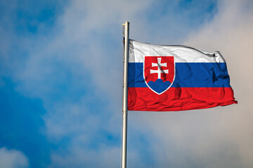 A Flag of Slovakia flying on a Flagpole against the Sky