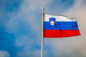 A Flag of Slovenia flying on a Flagpole against the Sky