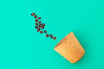 Top view of waffle cup with coffee beans on green background. Zero waste concept