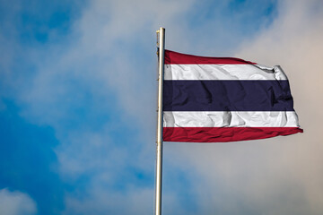 A Flag of Thailand flying on a Flagpole against the Sky